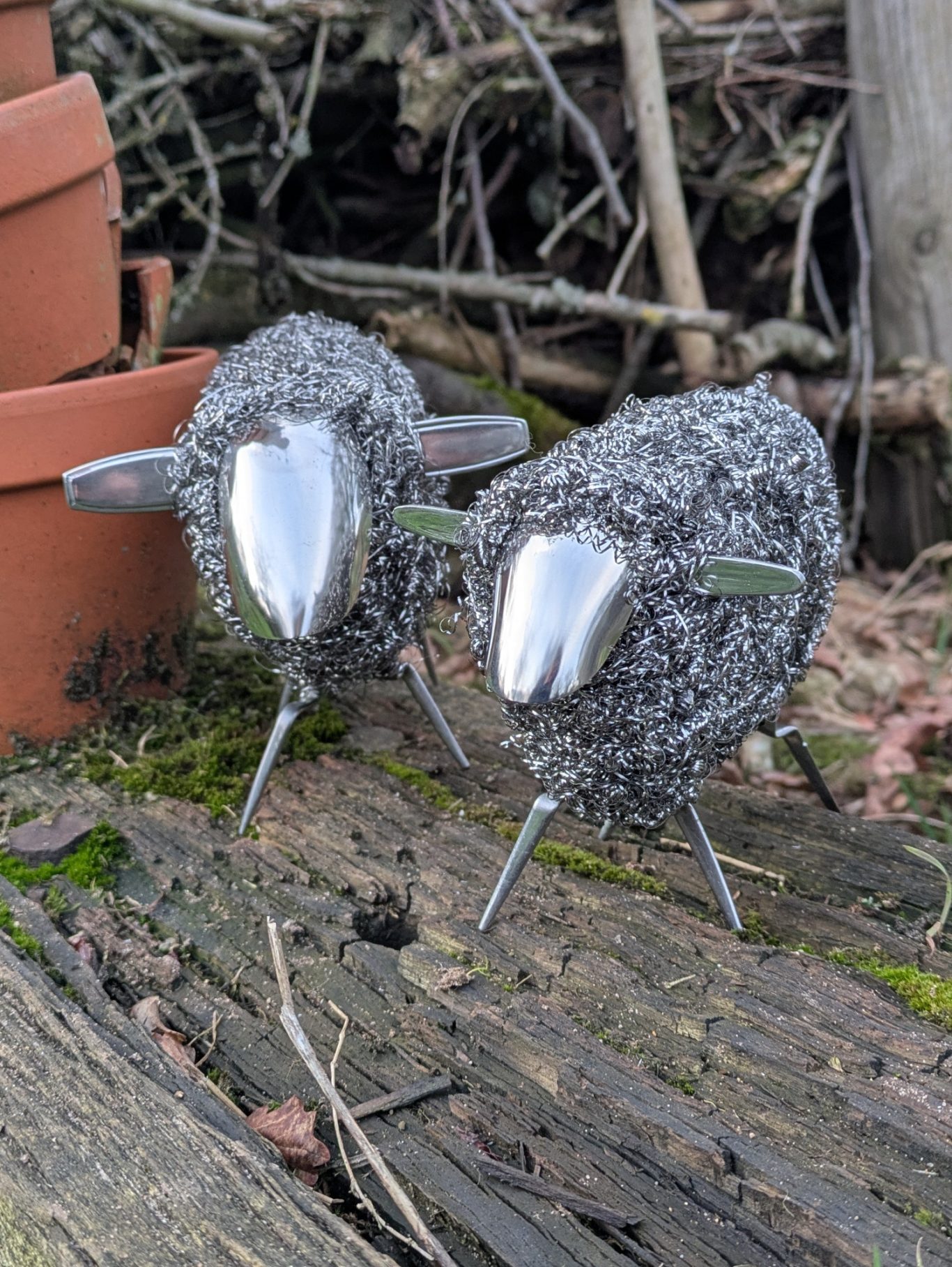 Schaf EdelLocke zwei Schaf aus Edelstahlbesteck und Edelstahlwolle vor Tontöpfen